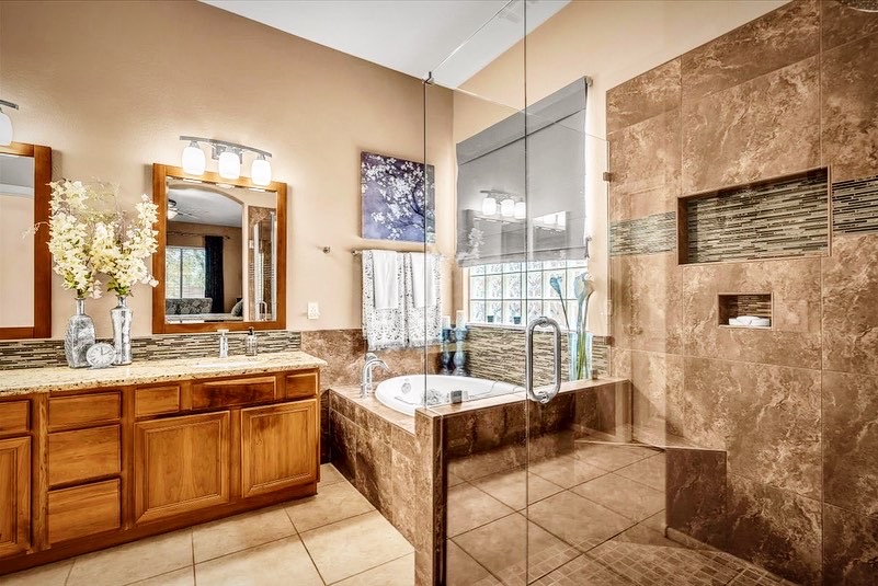 A bathroom with a large walk in shower and a bath tub.