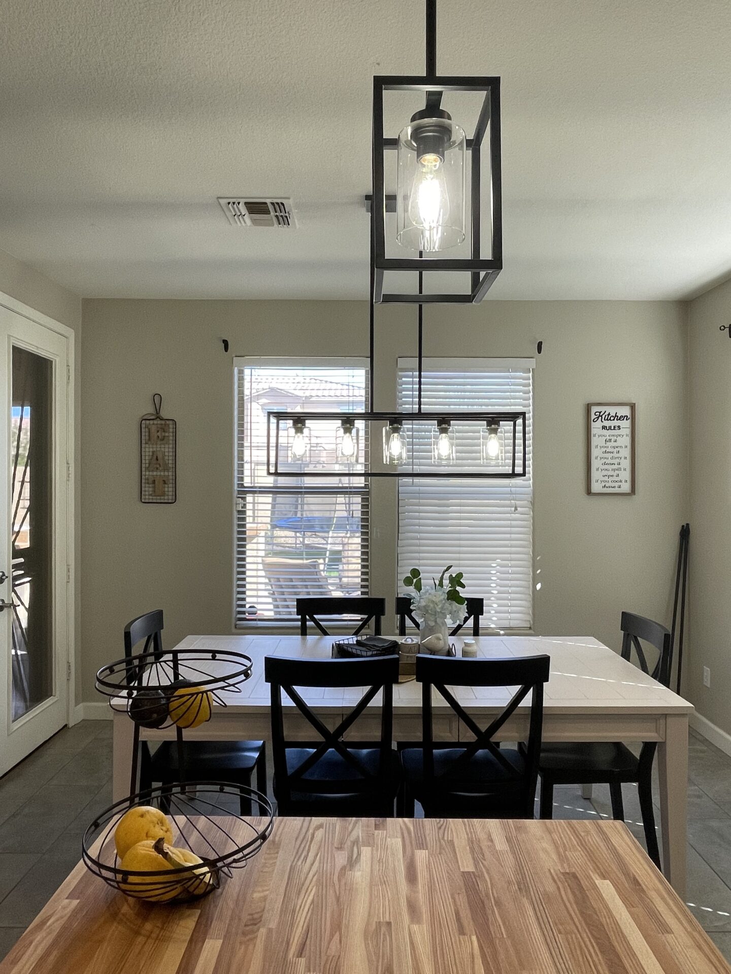 A dining room table with chairs and a light fixture.
