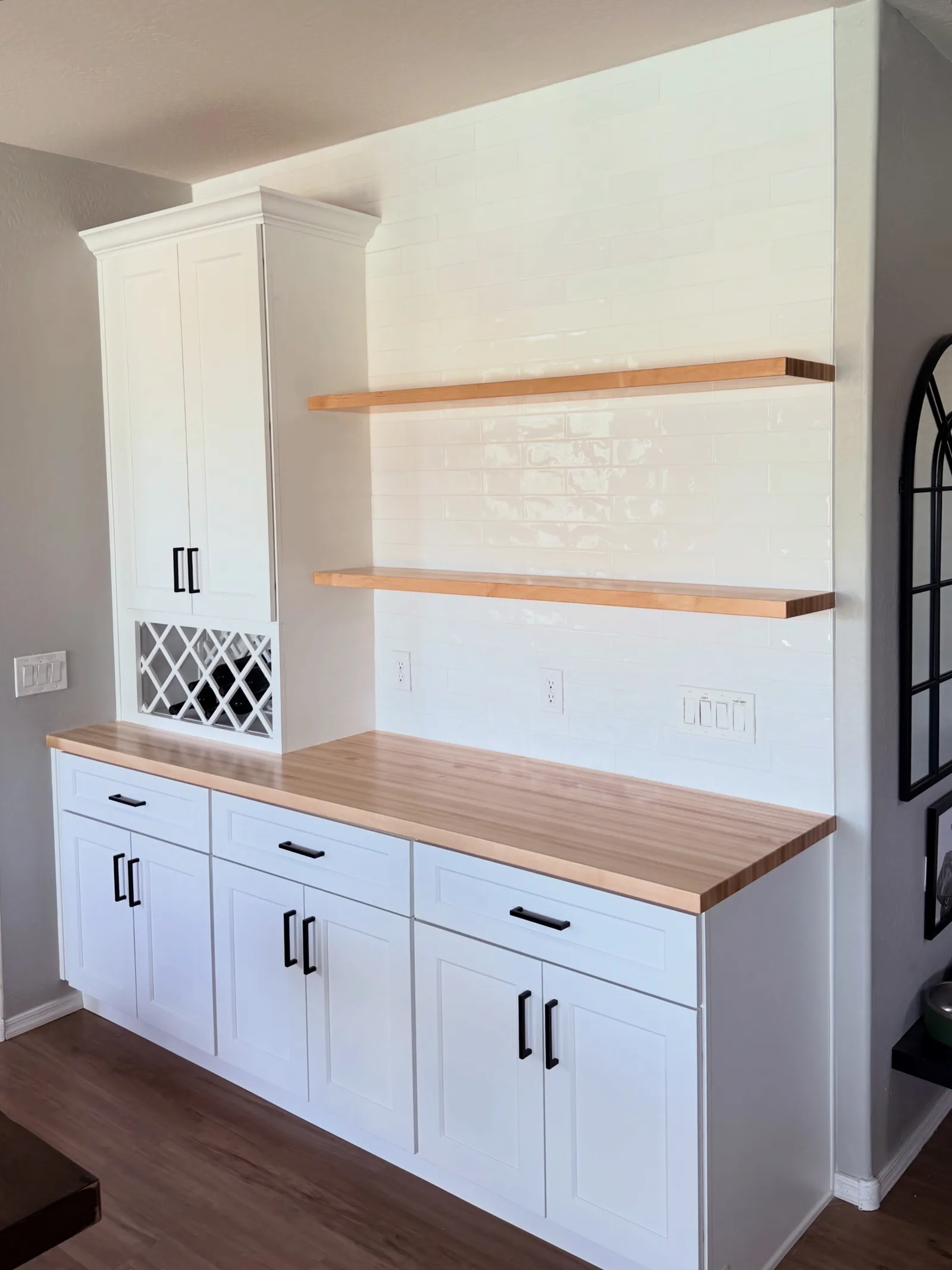 Modern white kitchen cabinetry with wood countertop, open shelving, and decorative lattice panel detail