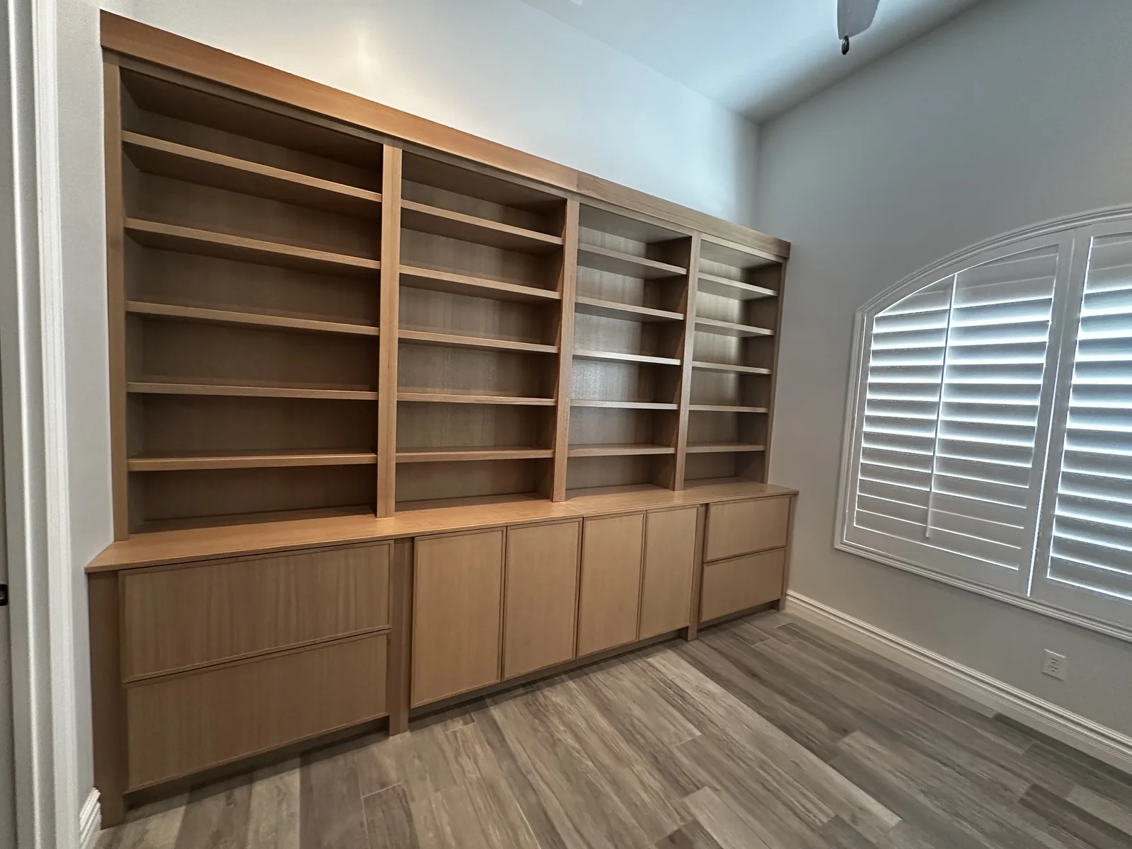 Custom wooden built-in bookcase with shelving and lower cabinetry in modern home office, Cincinnati