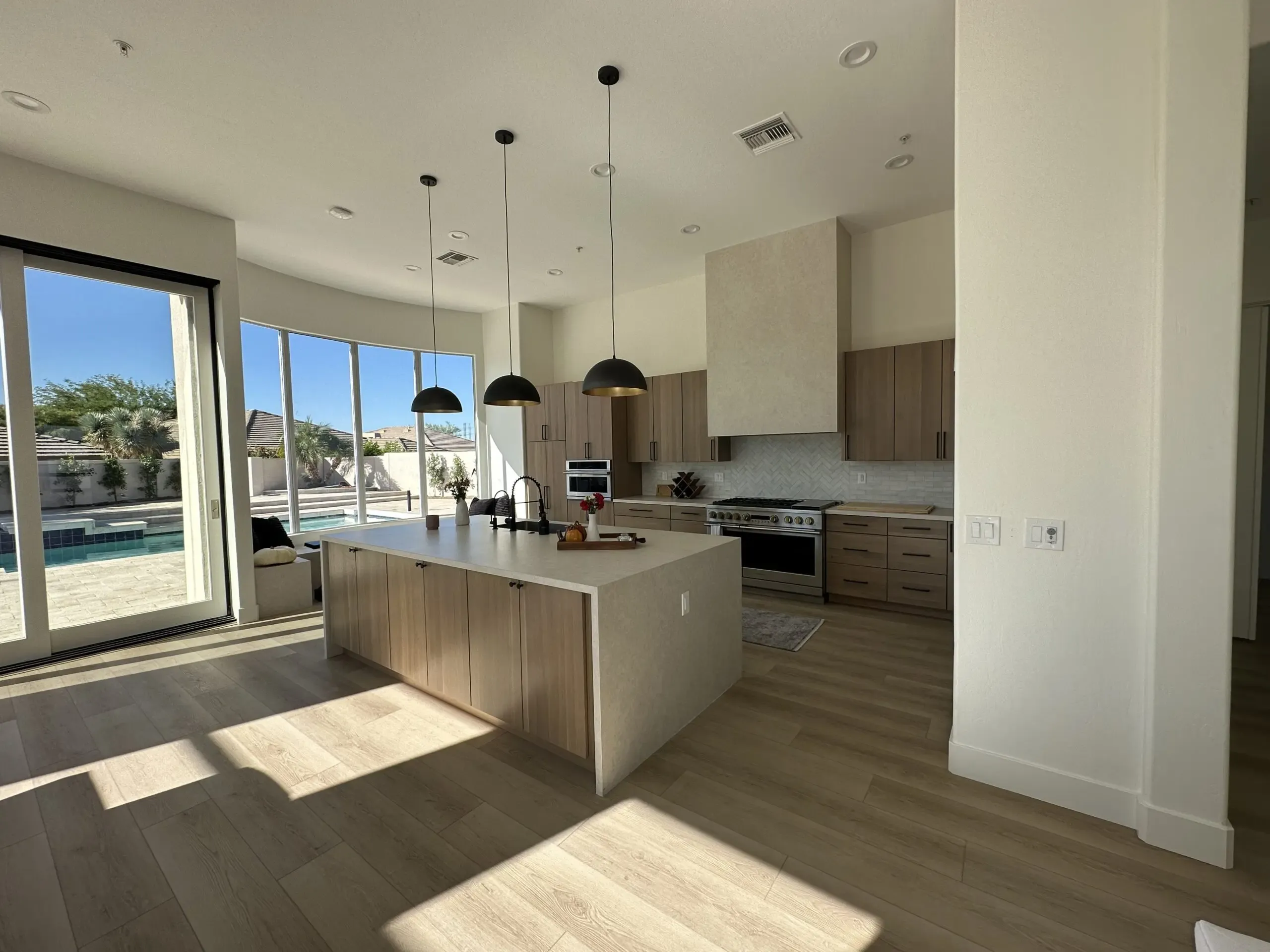 kitchen-background2 Modern Gold Canyon kitchen remodel with large island, custom cabinetry, pendant lighting, and pool views